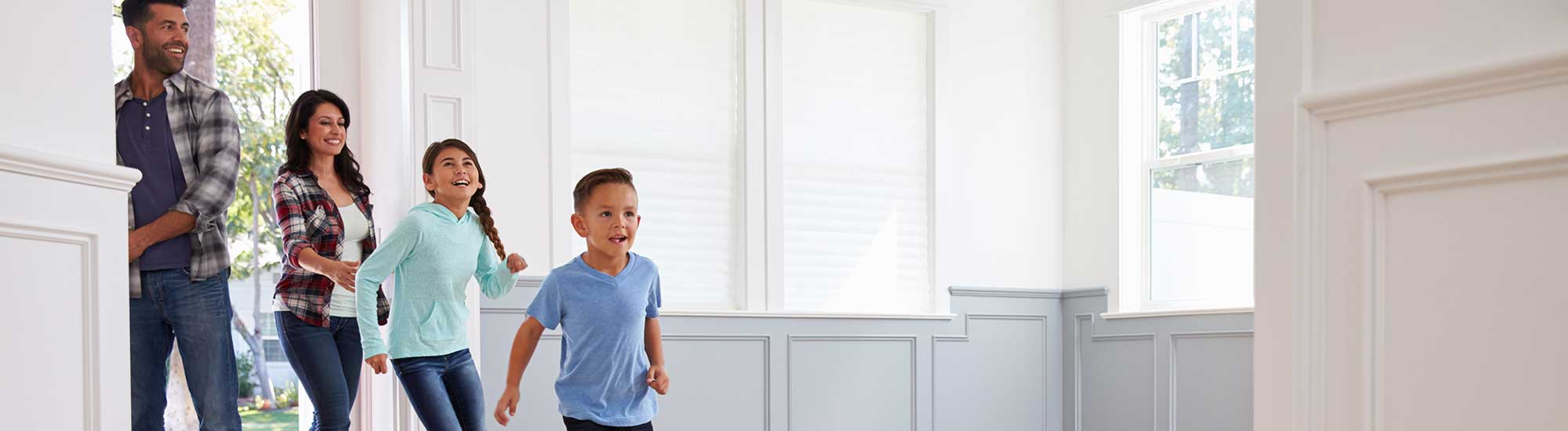 young family walking into new home