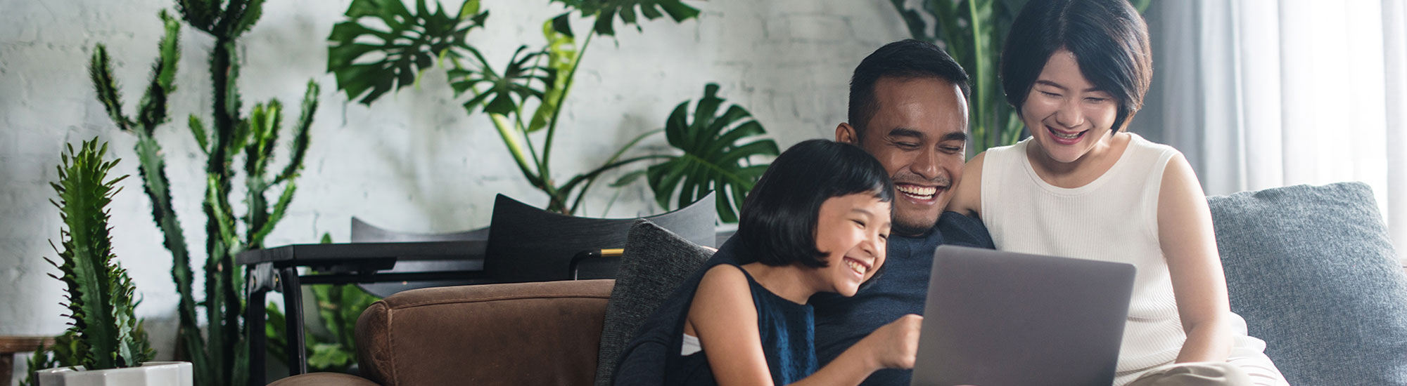 happy family in living room looking at laptop screen